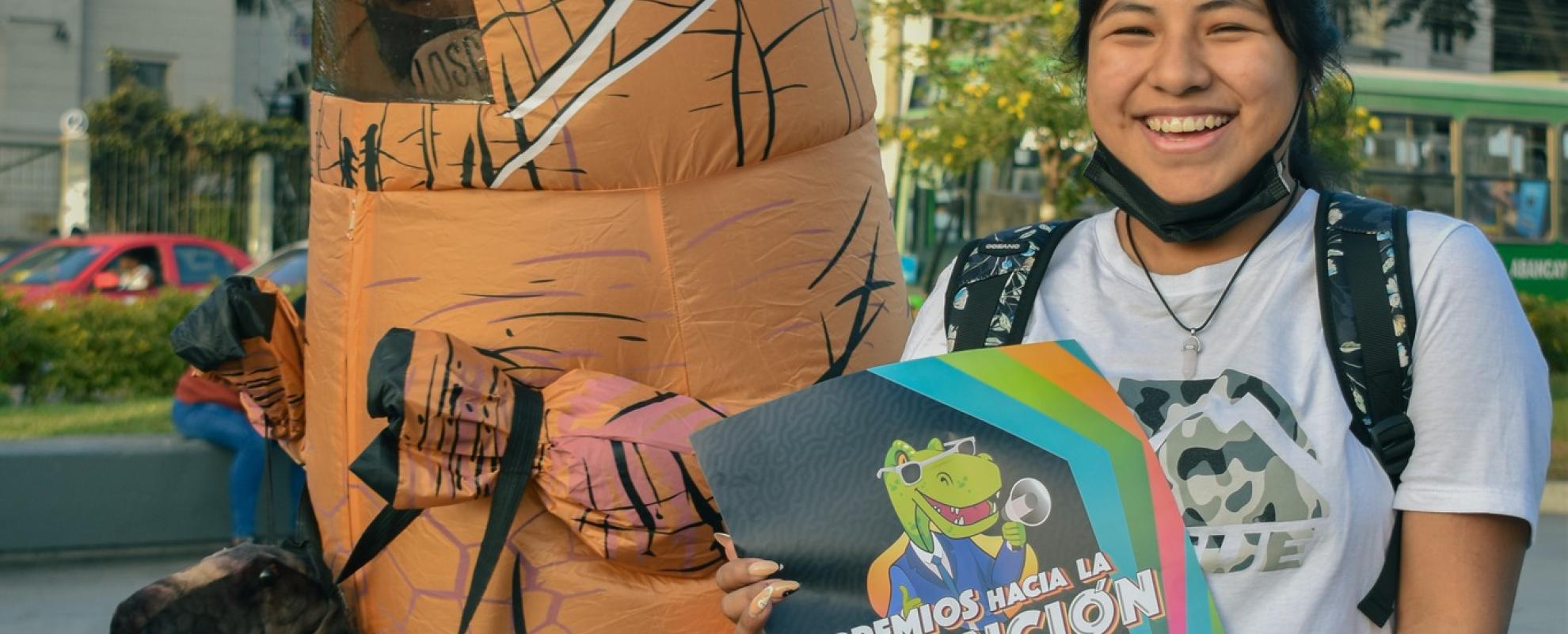 Dinosaurus en meisje met affiche 'Premios hacia la Extinción'