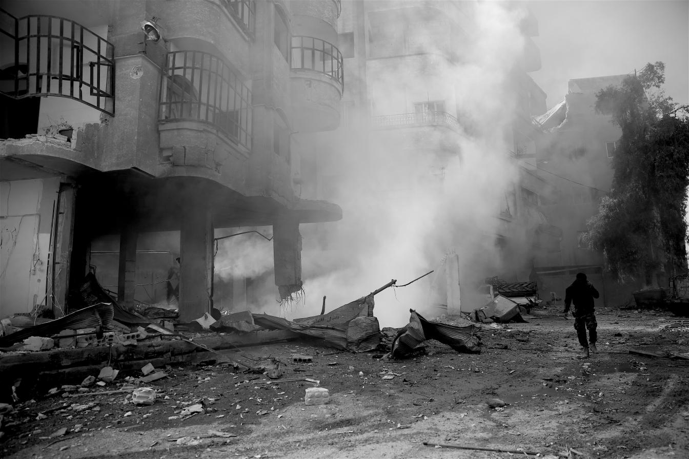 Man loopt weg van bombardement in Syrië