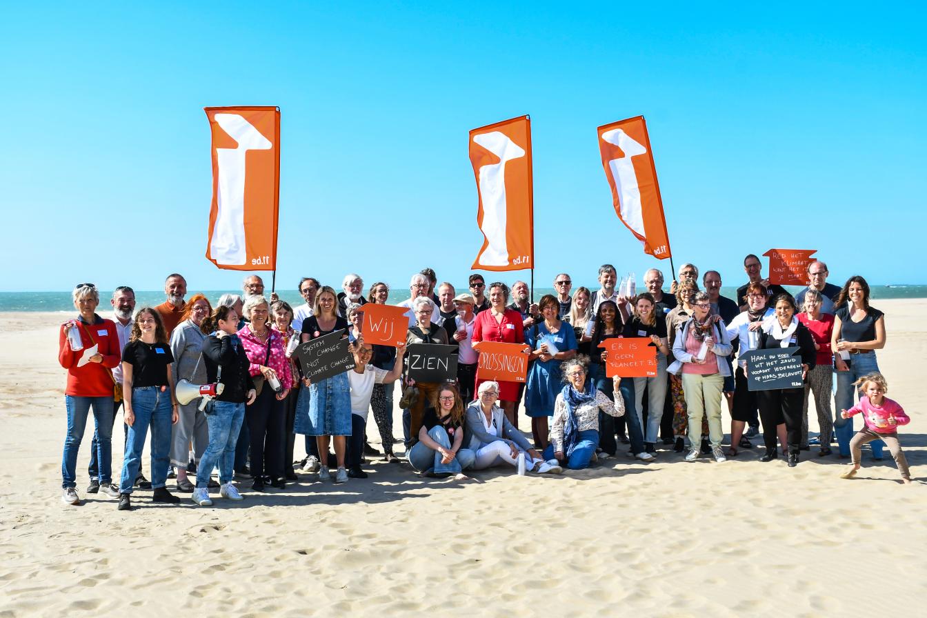 Groep vrijwilligers op het strand van Oostende met de nieuwe 11.vlaggen